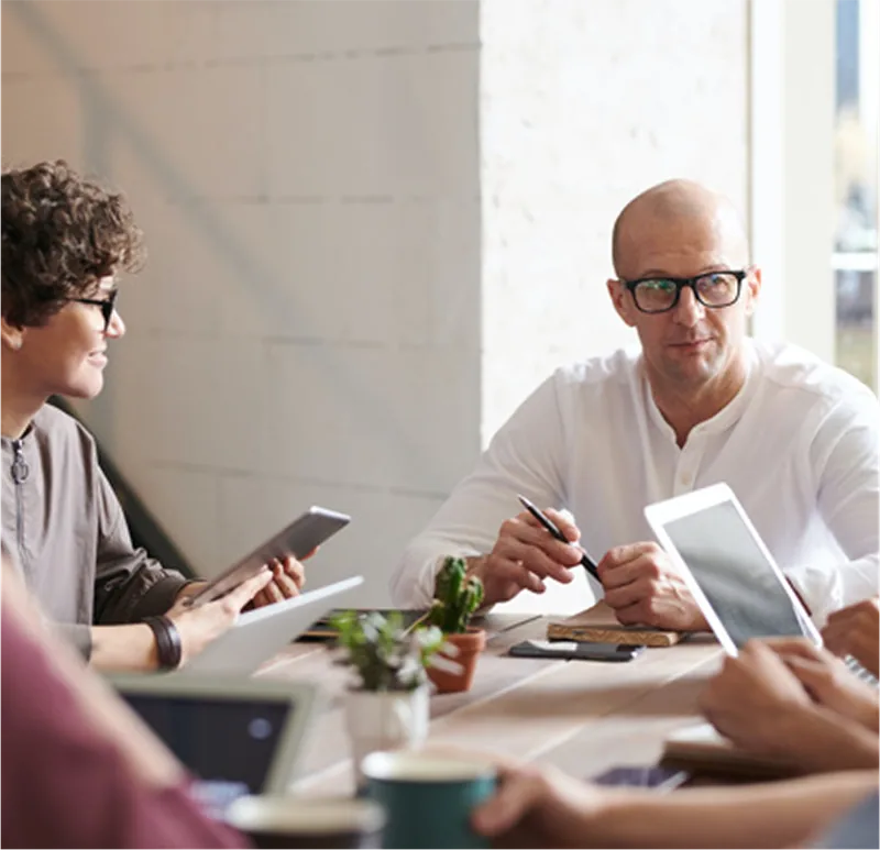 Team meeting around a table with tablets