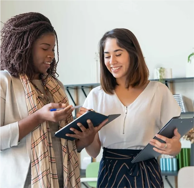 Two colleagues reviewing work on a tablet